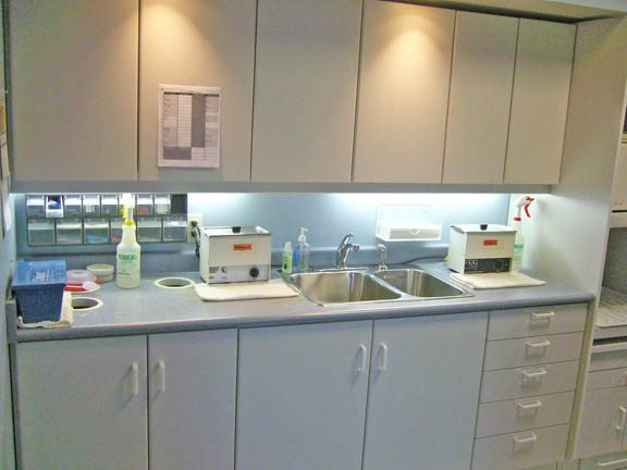 Sterilization counter with sink and several boxes under cabinets at Terrance J. O'Keefe, DDS, LLC in Penfield, NY