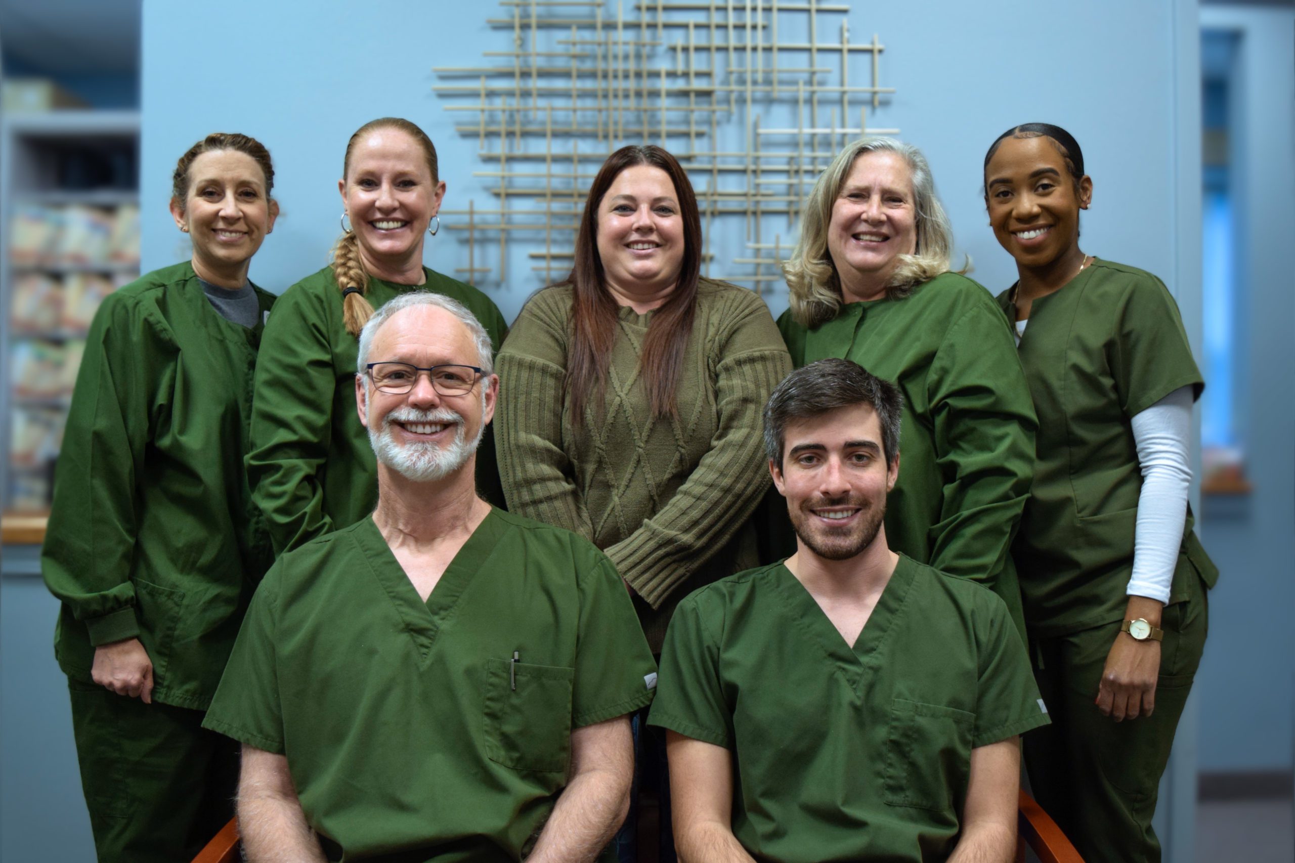 The entire staff of at Terrance J. O'Keefe, DDS, LLC wearing green dental scrubs in Penfield, NY